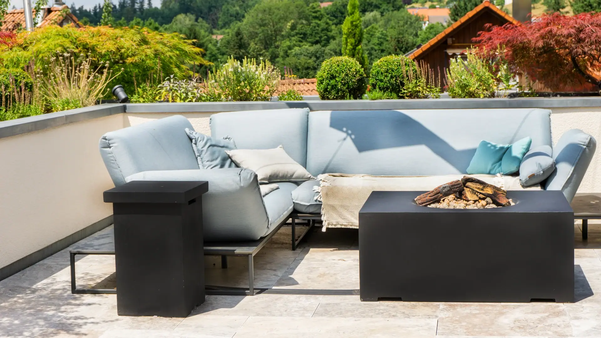 Helle Gartenlounge mit quadratischer Feuerstelle.