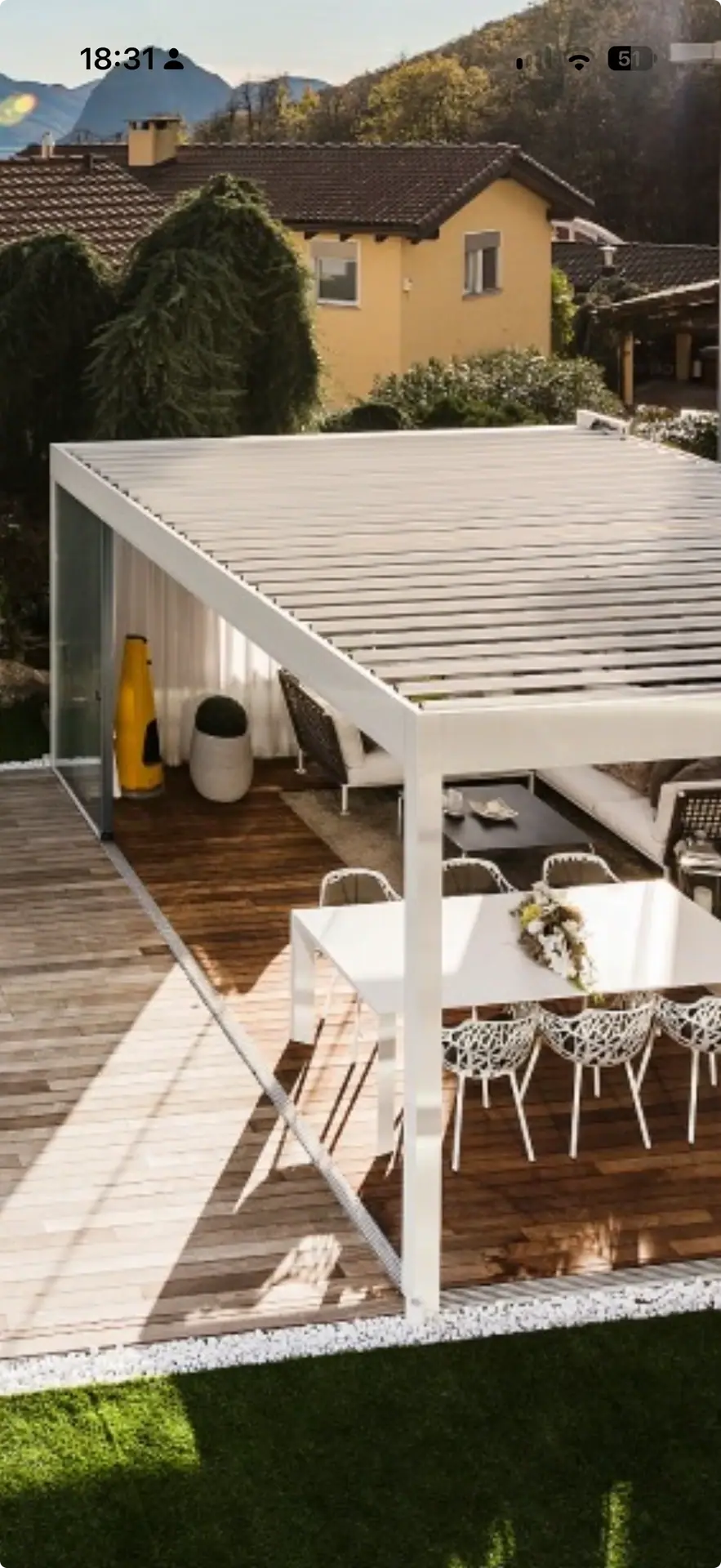 Terrassenüberdachung an einem Haus mit Gartenmöbeln.